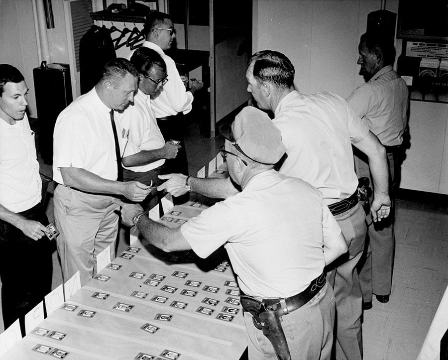 Trusted-Ally-Home-Care-rocky-flats-plant-workers-checking-in-for-work-in-the-clock-room-in-1967